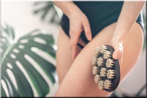 Femme pratiquant le brossage à sec sur les cuisses avec une brosse en fibres naturelles pour réduire la cellulite et stimuler la circulation lymphatique